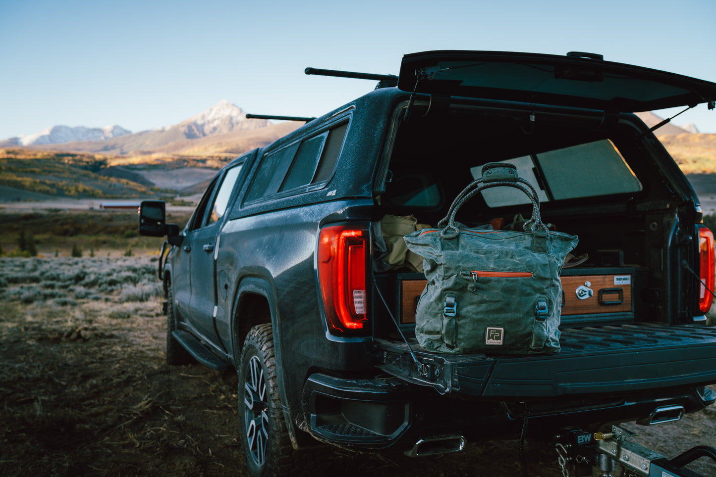 SUV with open trunk in a mountainous landscape